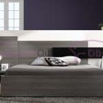 Modern grey laminated platform bed with extended asymmetrical geometric headboard, black horizontal accent and matching floating bedside cabinets